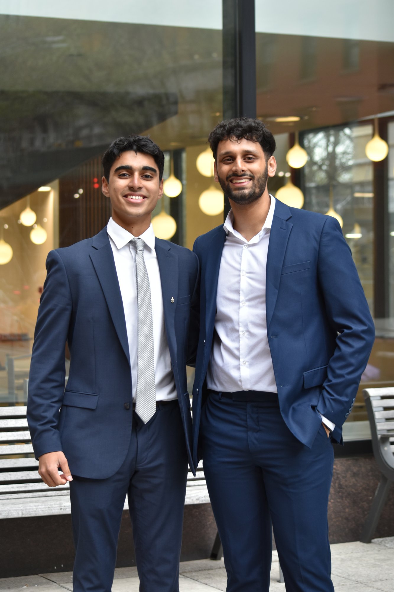 Two brothers in suits outside a chapter event