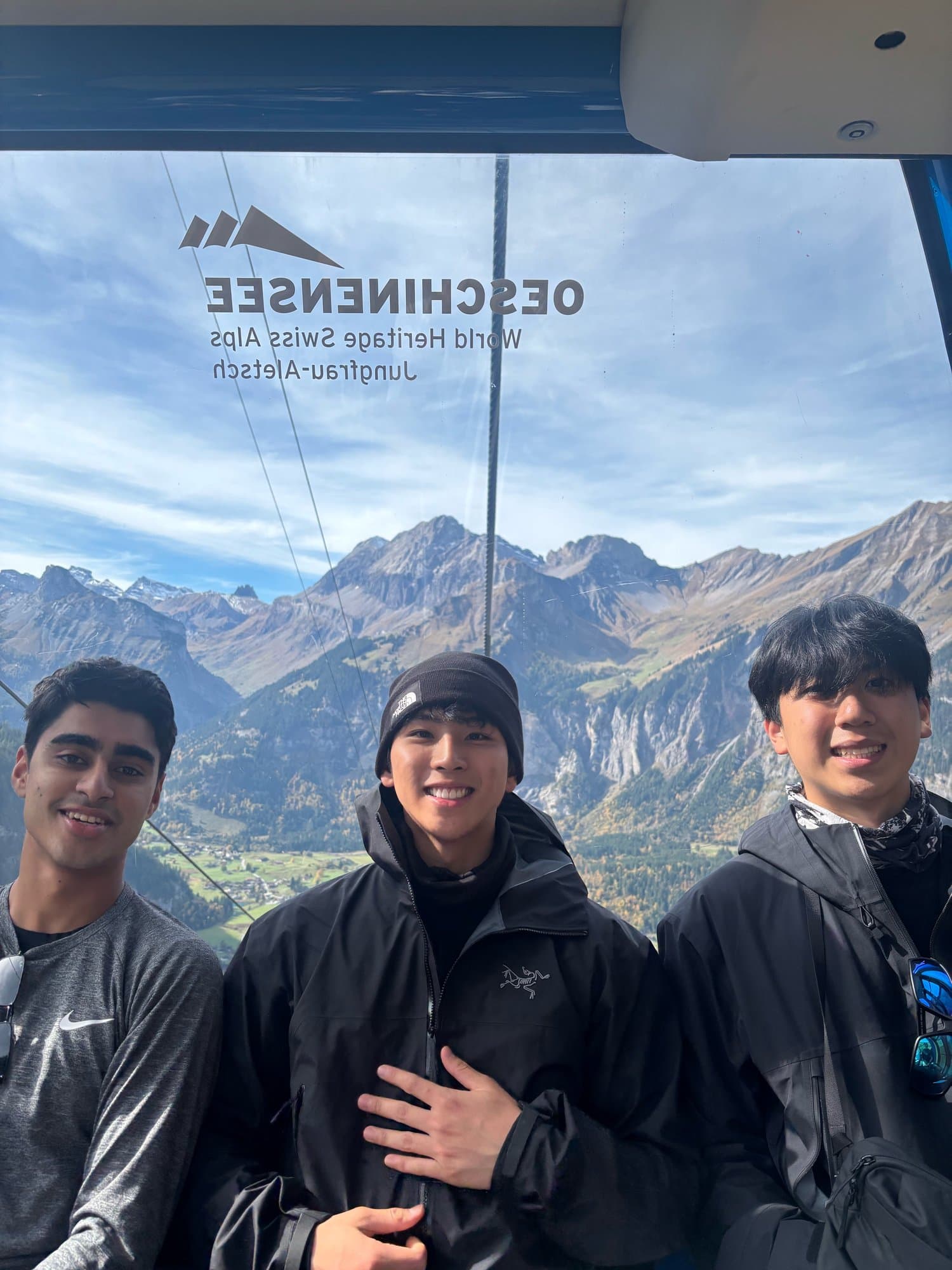 Three brothers in a gondola above the Swiss Alps