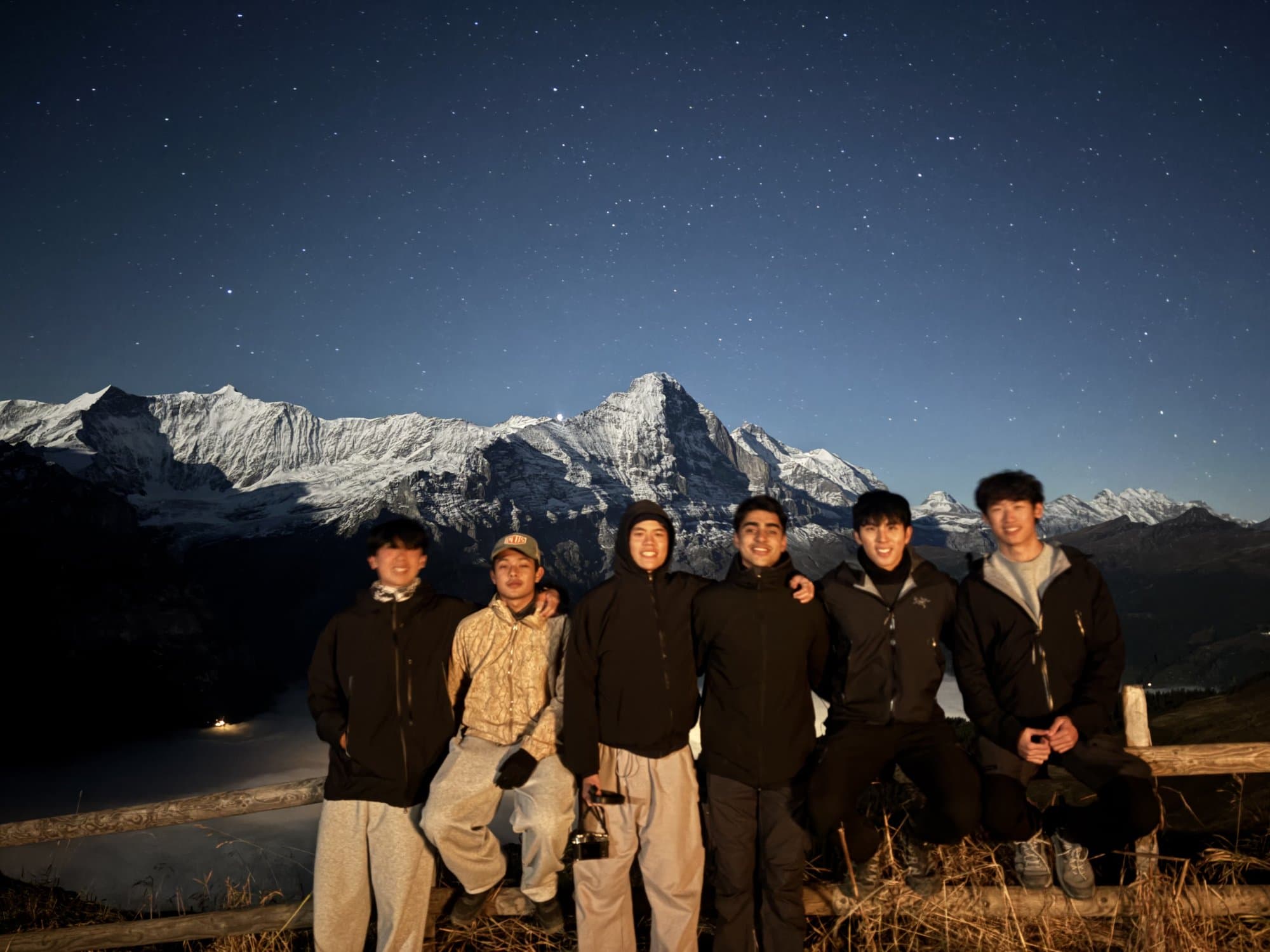 Brothers under the stars in front of snowy peaks